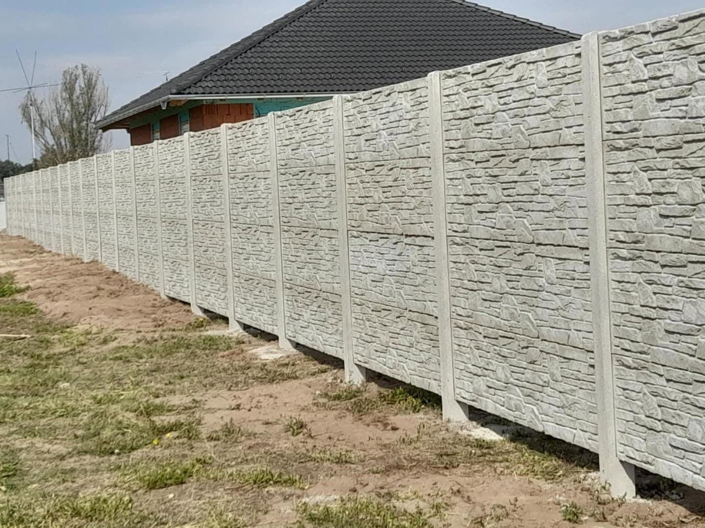 Elkészült kőmintás betonkerítés hosszú telekhatáron
